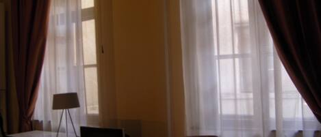 A room with a TV, a desk, a chair, and a table.