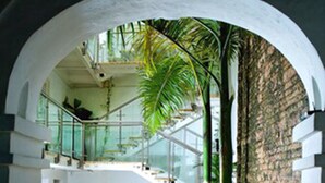A modern interior with a stone archway leading to a dining area with a table set for two.