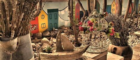 A miniature garden with a small boat, a birdcage with flowers, and colorful houses.
