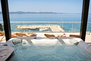 Un jacuzzi con vista al mar y un muelle con barcos.