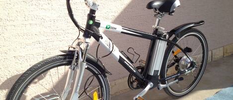 A bicycle parked against a wall with a window in the background.