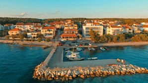 A coastal town with a marina, boats, and residential buildings. - Hotel Delfin (Zadar)