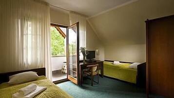 Una habitación con cama, escritorio, silla y ventana.