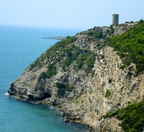A coastal cliff with a cylindrical structure on top, overlooking the sea. - Hotel Sancho III (Alcala de Xivert)