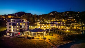 Hotel de diversos pisos amb un pati central, envoltat de jardins ben cuidats i vista a una vessant de muntanya.