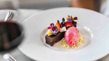 A dessert plate with a chocolate brownie, fruit, and ice cream.