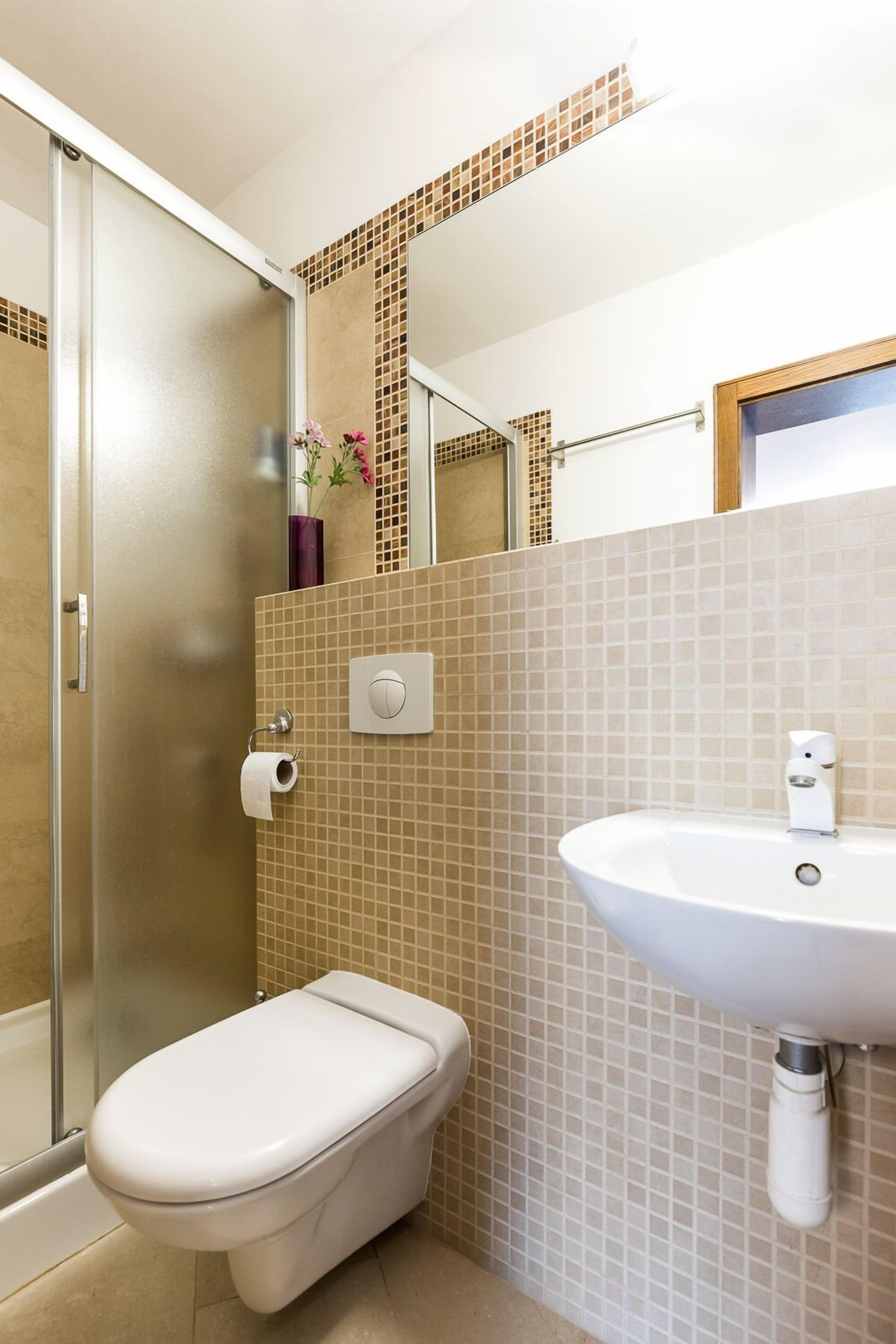 A bathroom with a toilet, sink, and shower.