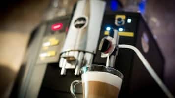 A close-up of a coffee machine with a glass cup of coffee.