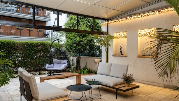 A modern outdoor patio with a sofa, chairs, and a dining table.