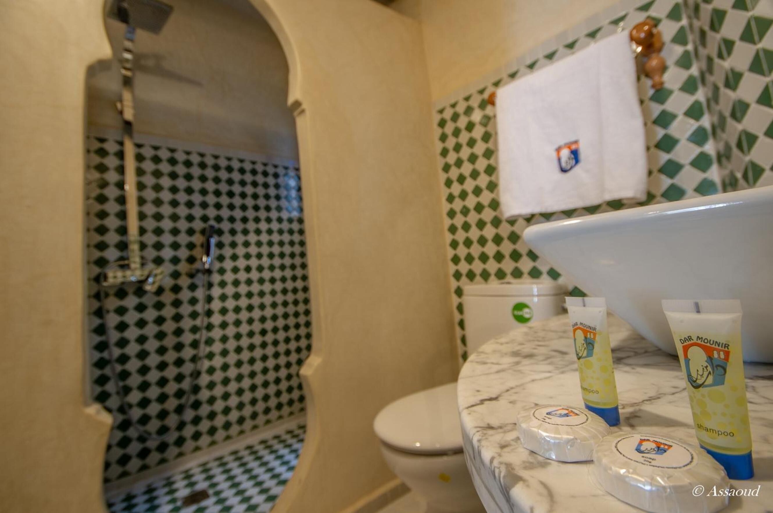 Un baño con un lavamanos blanco, dos artículos de aseo y un inodoro.