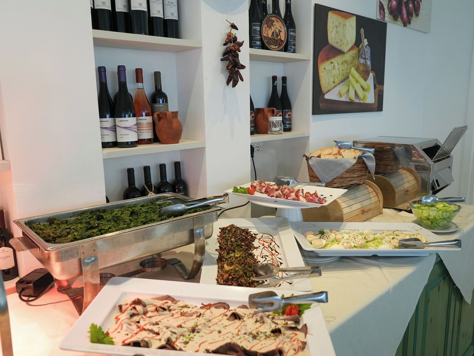 Een buffetopstelling met diverse gerechten en wijnflessen.