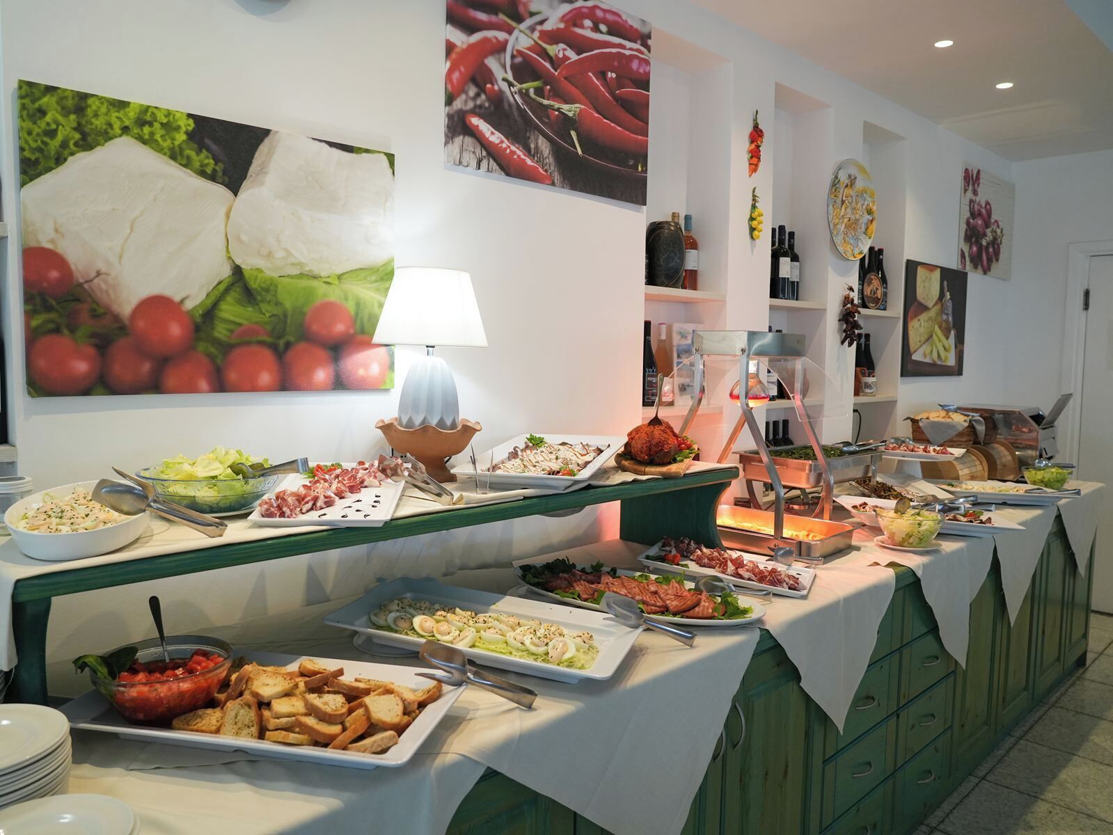 Montaje tipo bufé con diferentes alimentos y una lámpara decorativa.