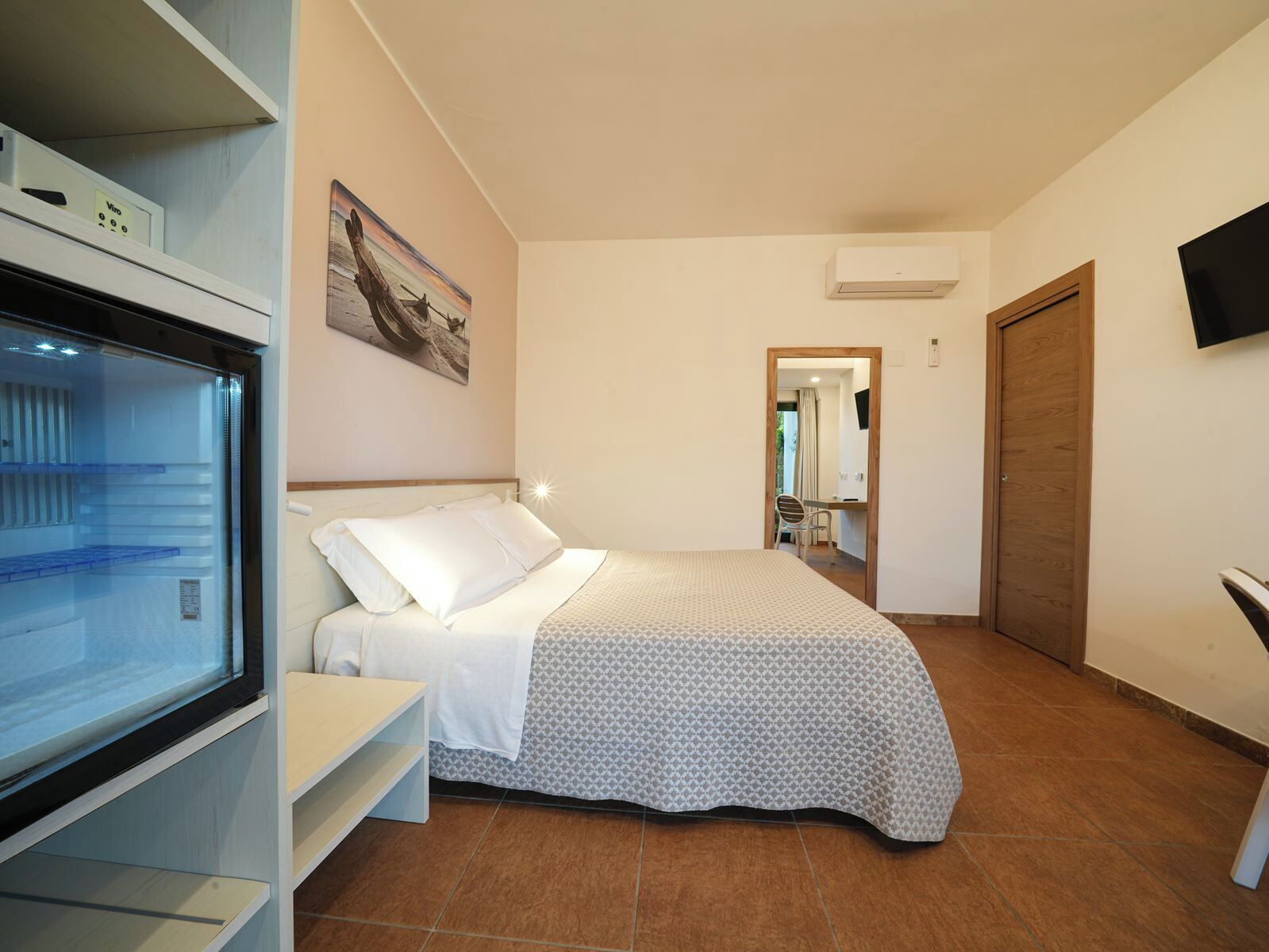 Un dormitorio con cama, escritorio y televisor.