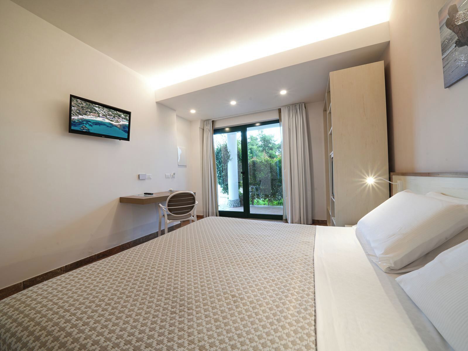 Une chambre d’hôtel moderne avec un grand lit, un bureau et une chaise.