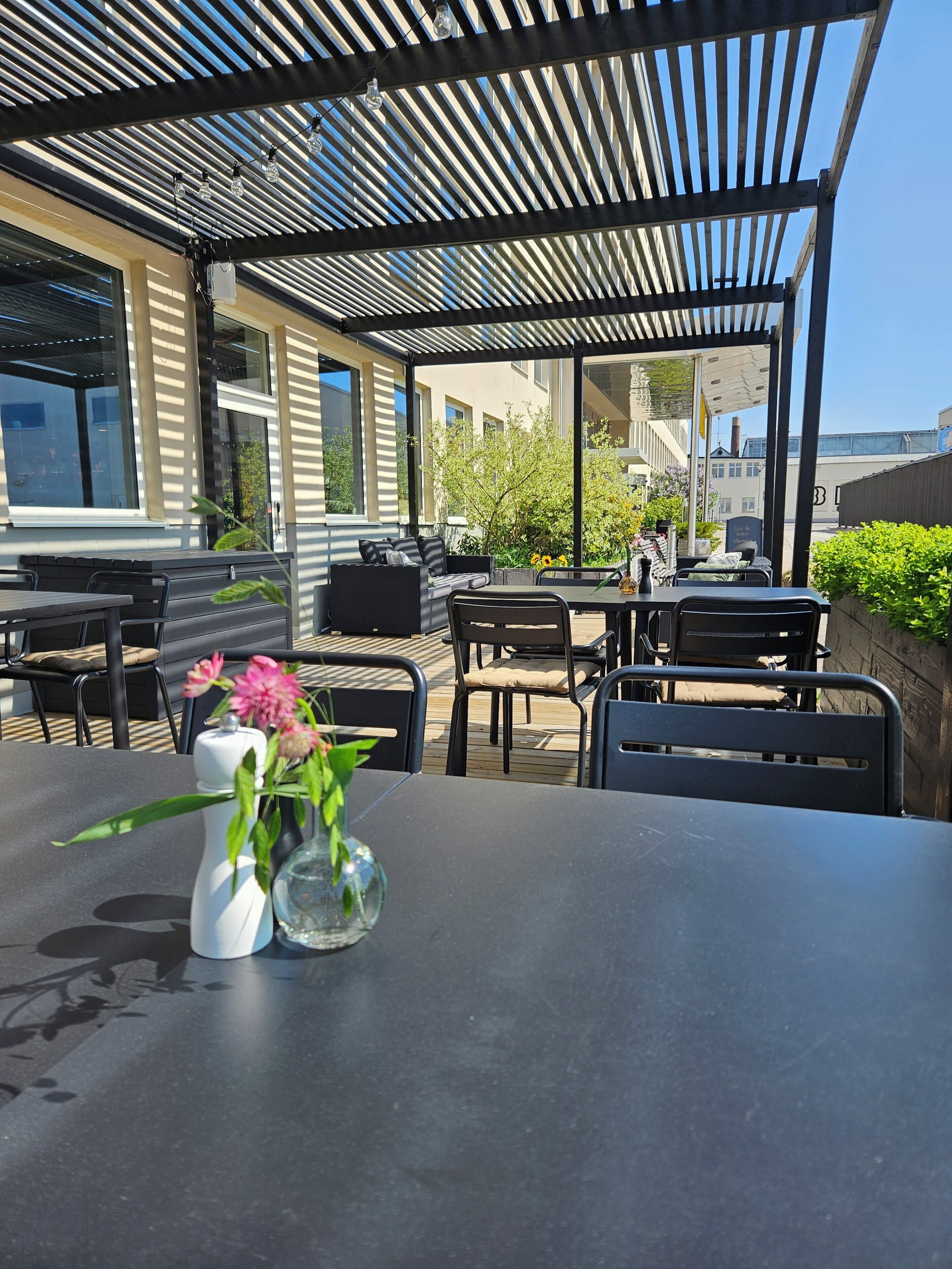 An outdoor patio area with a table, chairs, and a pergola structure.