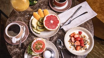 A table with breakfast items including toast, fruit, yogurt, and coffee.