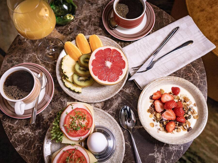 A table with breakfast items including toast, fruit, yogurt, and coffee.