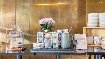 A breakfast buffet with various food items, including pastries, dairy products, and beverages.