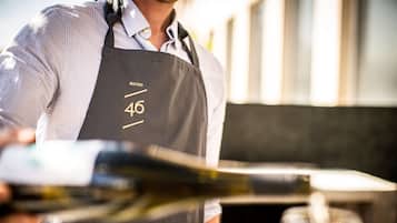 A person wearing a black apron with the number 46 and the word "BISTRO" on it.