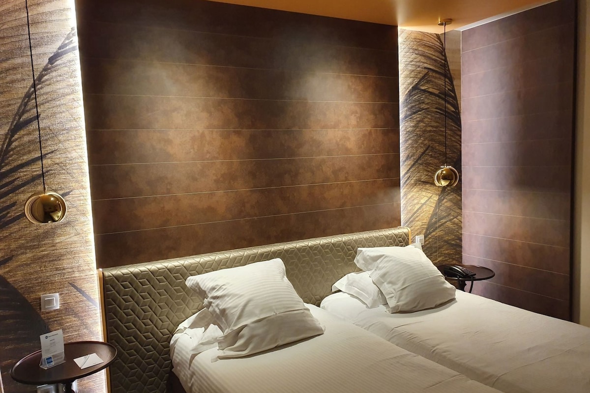Een hotelkamer met een groot bed, een klein tafeltje en een muur met een structuur.