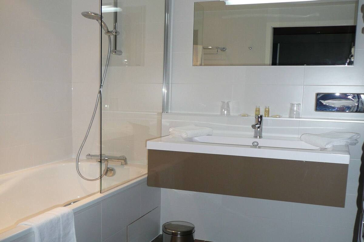 bathtub, hair dryer, bathrobes, towels