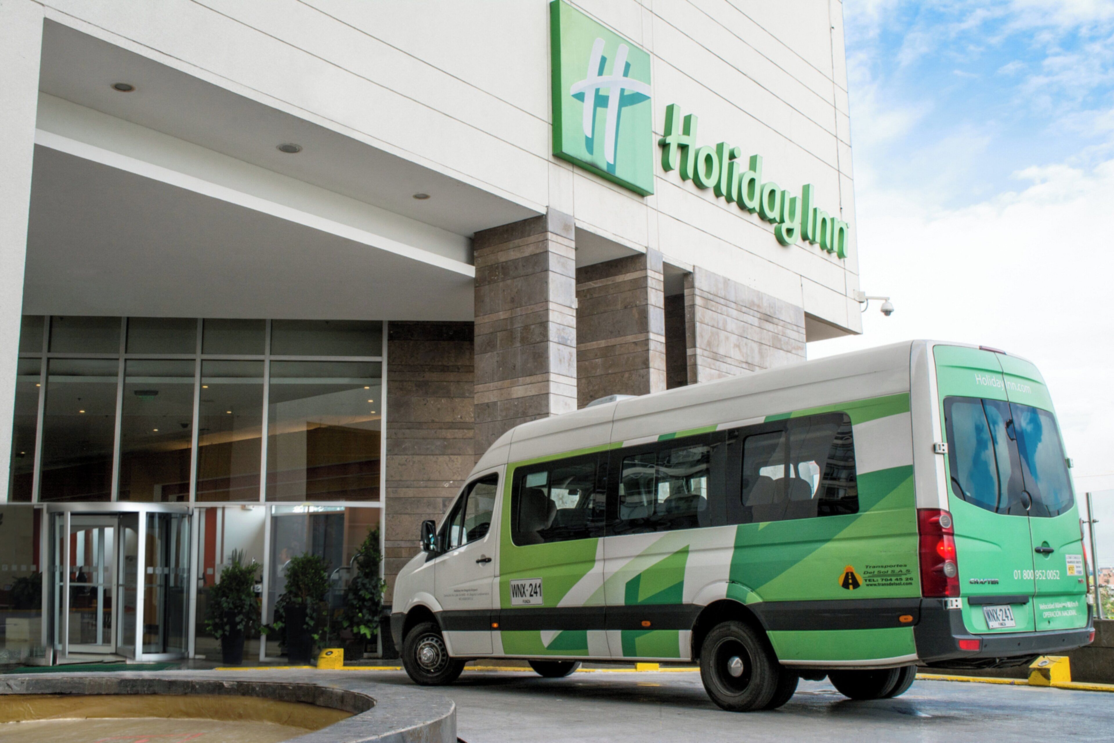 A Holiday Inn Express hotel with a green and white van parked in front.