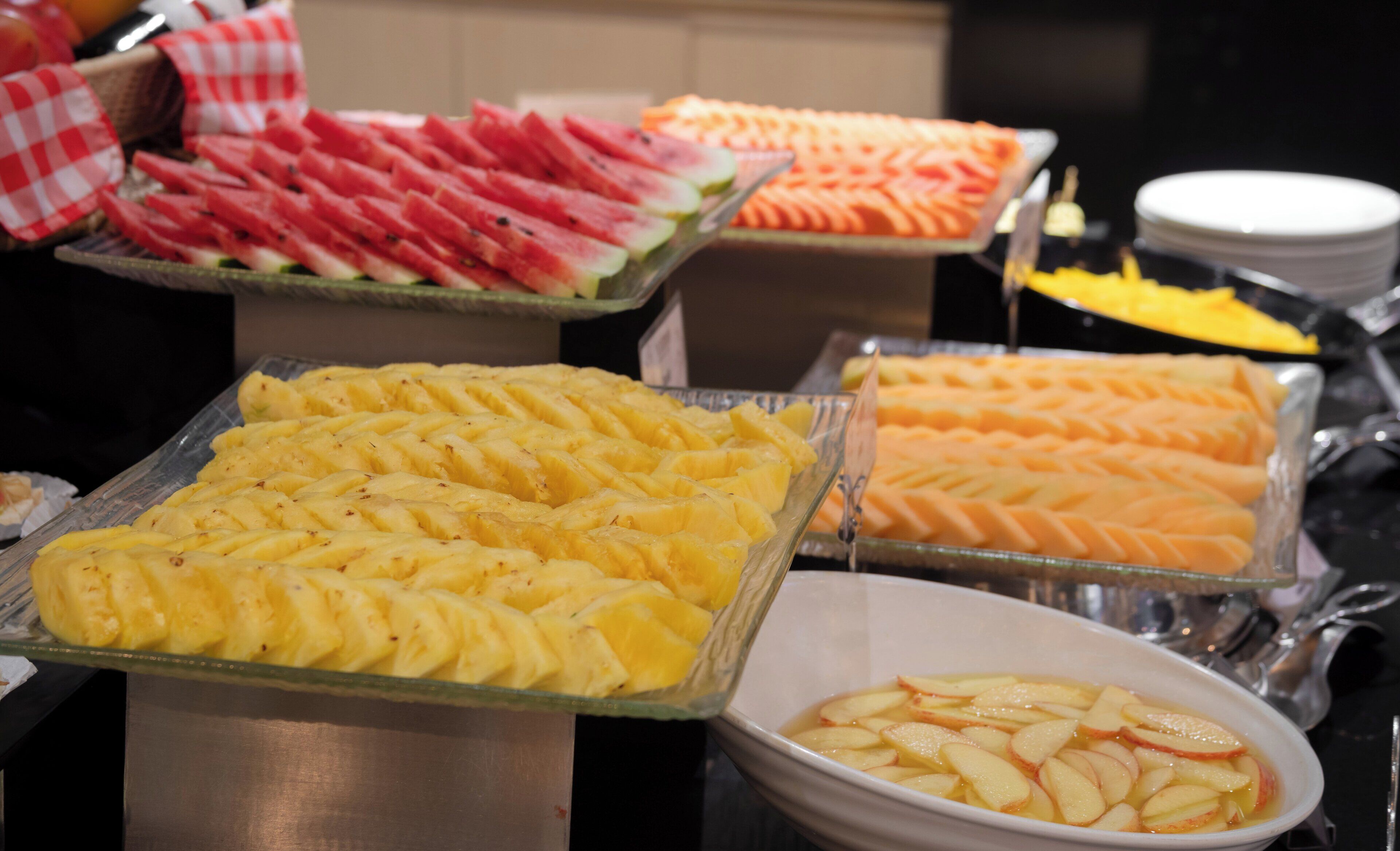 A buffet with various fruits and desserts.