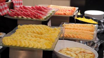 A buffet with various fruits and desserts.
