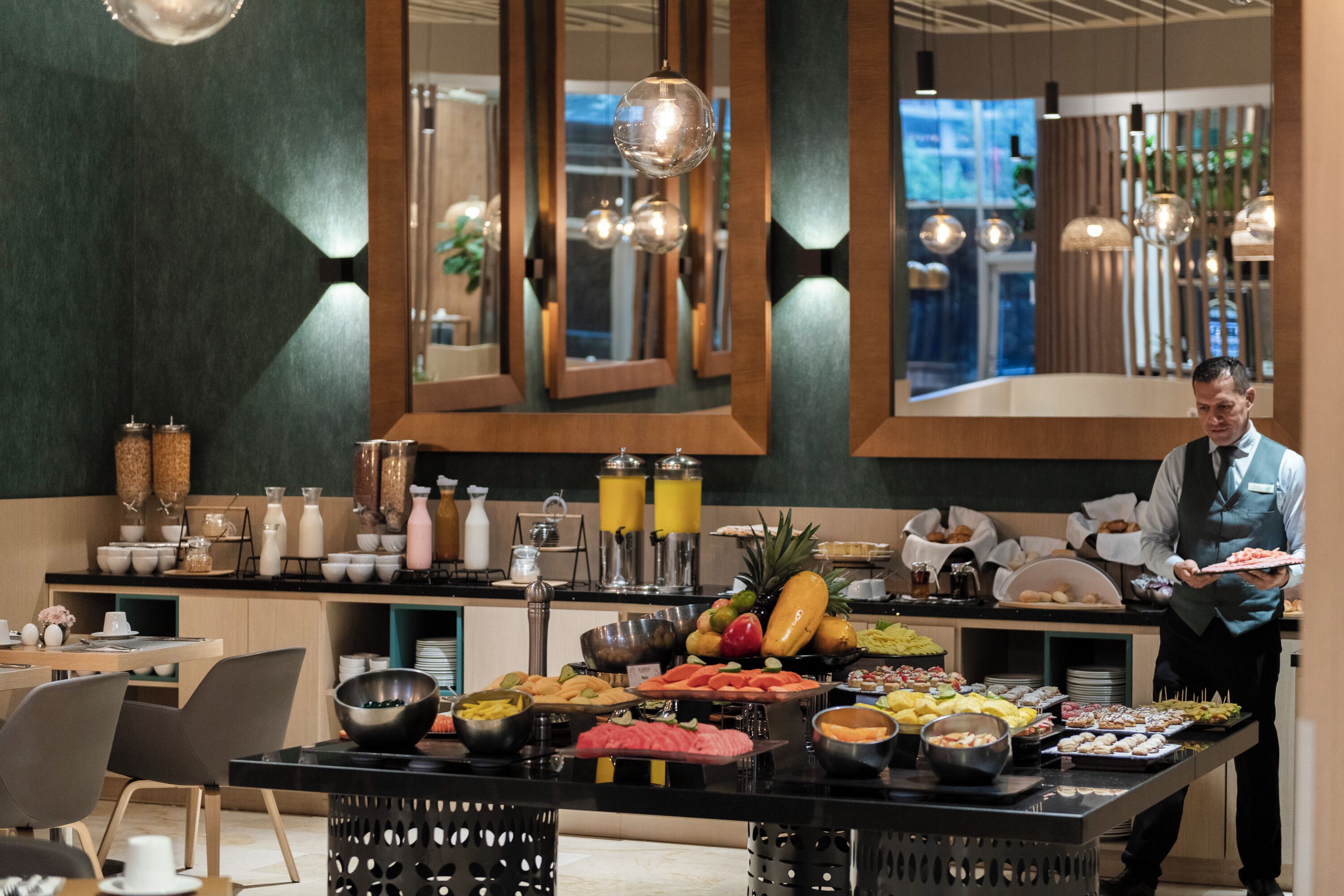 Un buffet proposant une variété de plats, avec un serveur qui s’occupe de servir les clients.