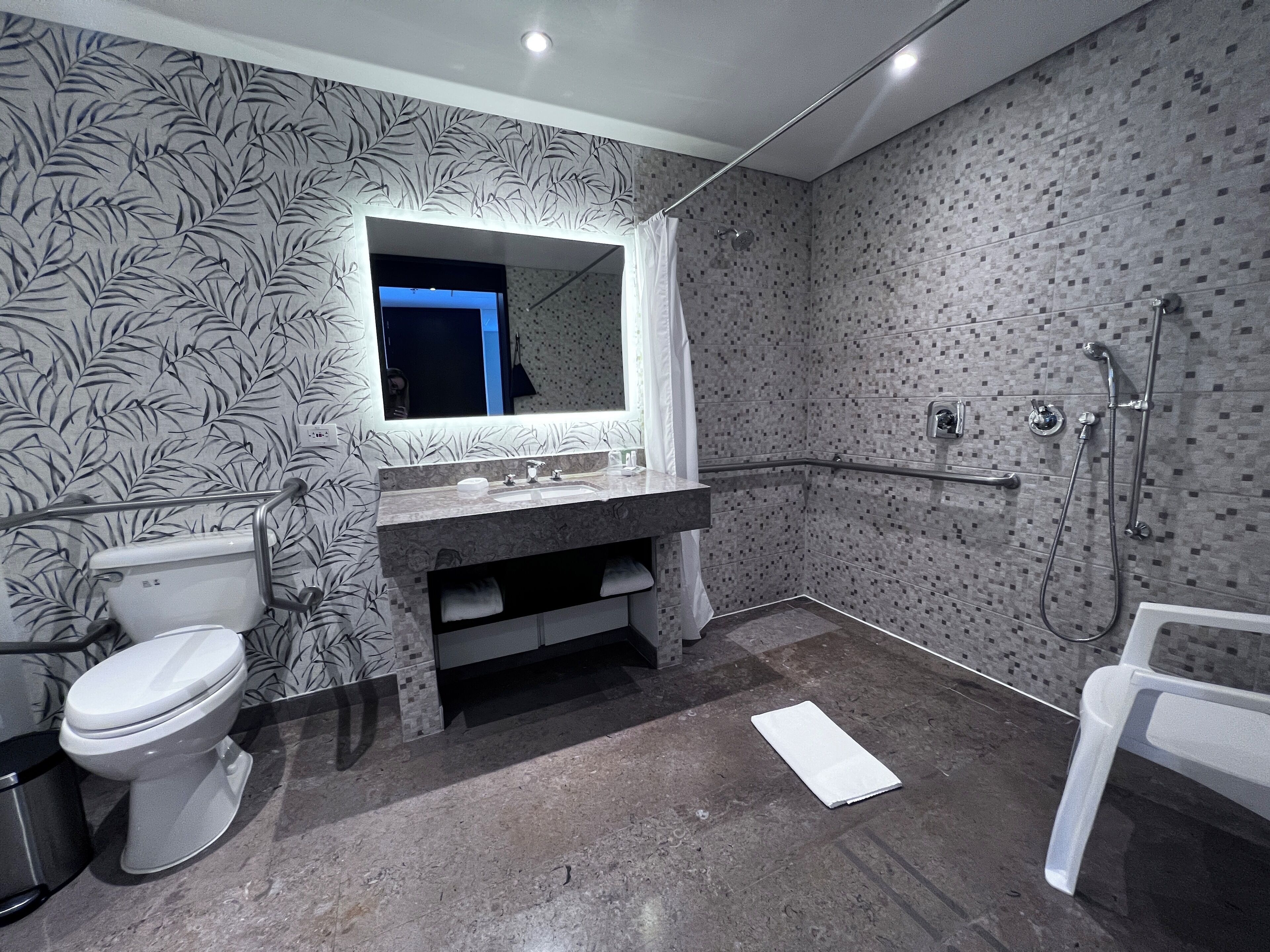 Een moderne badkamer met toilet, wastafel en douche.