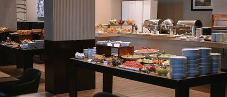 Una mesa de buffet con diferentes alimentos y utensilios.