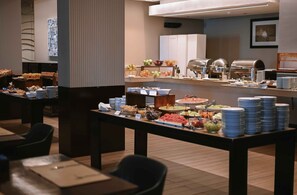 Una mesa de buffet con diferentes alimentos y utensilios.