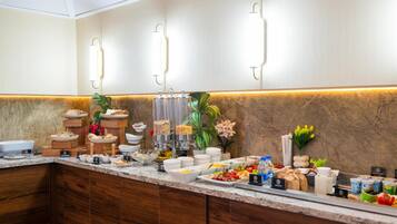 Montaje de bufé con diferentes alimentos y una barra de madera.