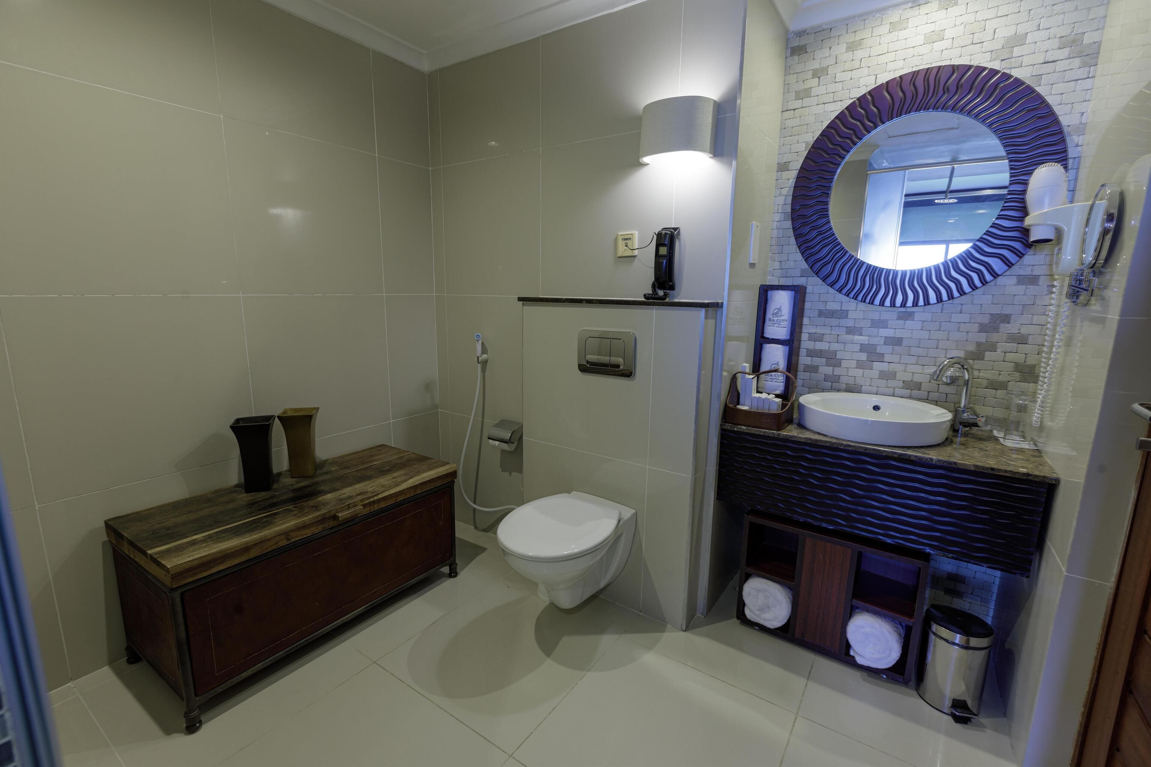 A modern bathroom with a toilet, sink, vanity, and shower.