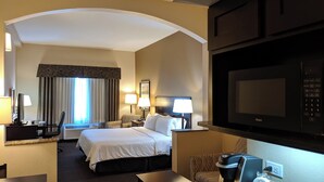 Une chambre d’hôtel équipée d’un lit, d’un bureau, d’une chaise, de lampes et d’un téléviseur.