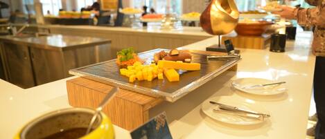 A buffet setup with various food items and utensils.