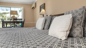 A hotel room with a bed, a desk, and a chair. - The Boat House (Marco Island)