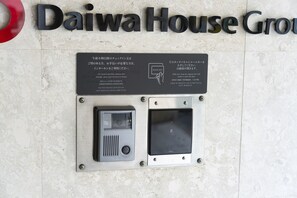 Ein Schild der Daiwa House Group mit einer Sicherheitstafel und einem Chipkartenleser für Zimmerschlüssel.