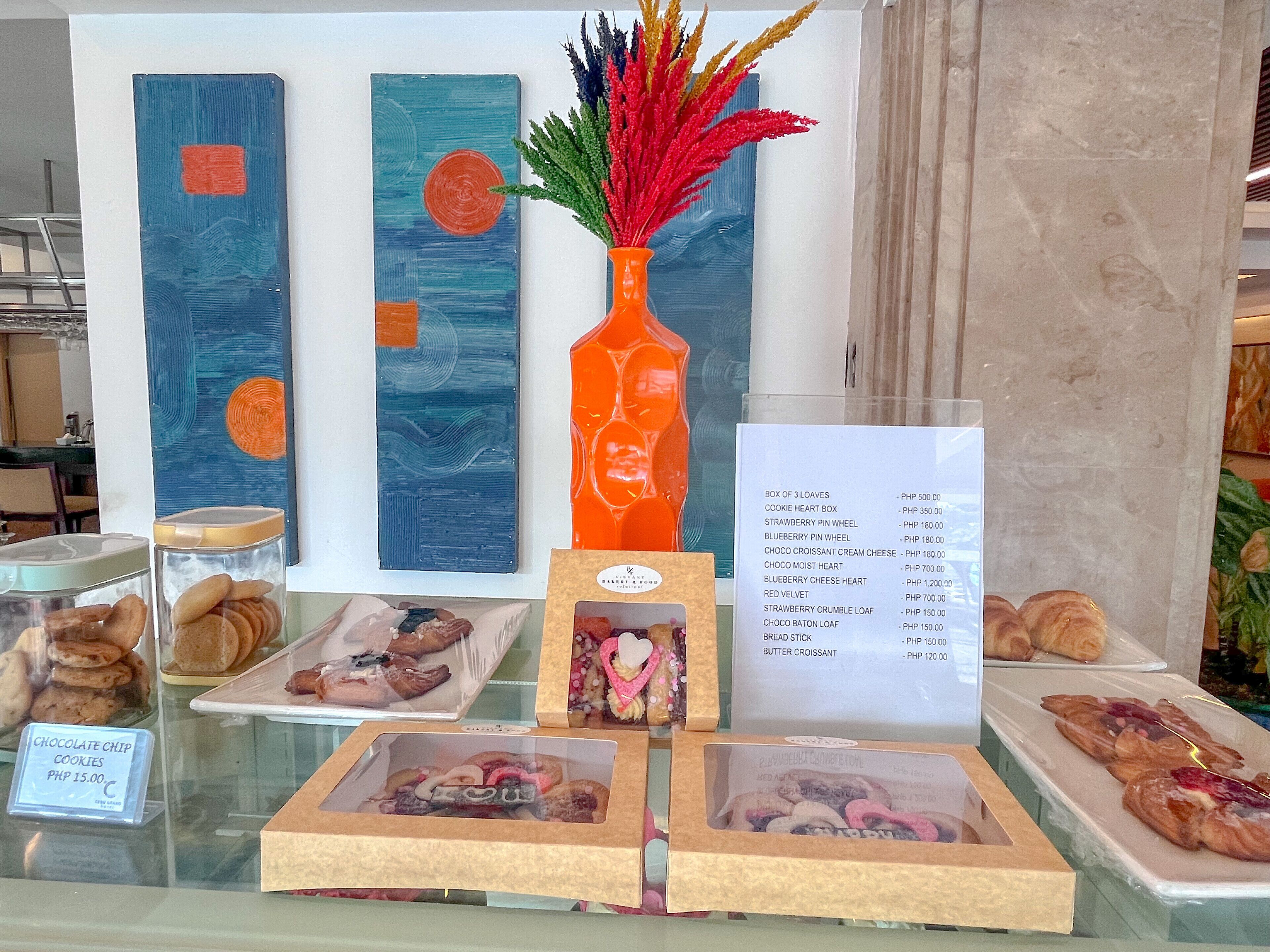 A bakery display with pastries and a menu listing prices.