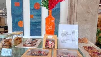 A bakery display with pastries and a menu listing prices.