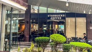 Starbucks-kahvila, jossa on ulkotila, moderni julkisivu ja kirkas taivas.