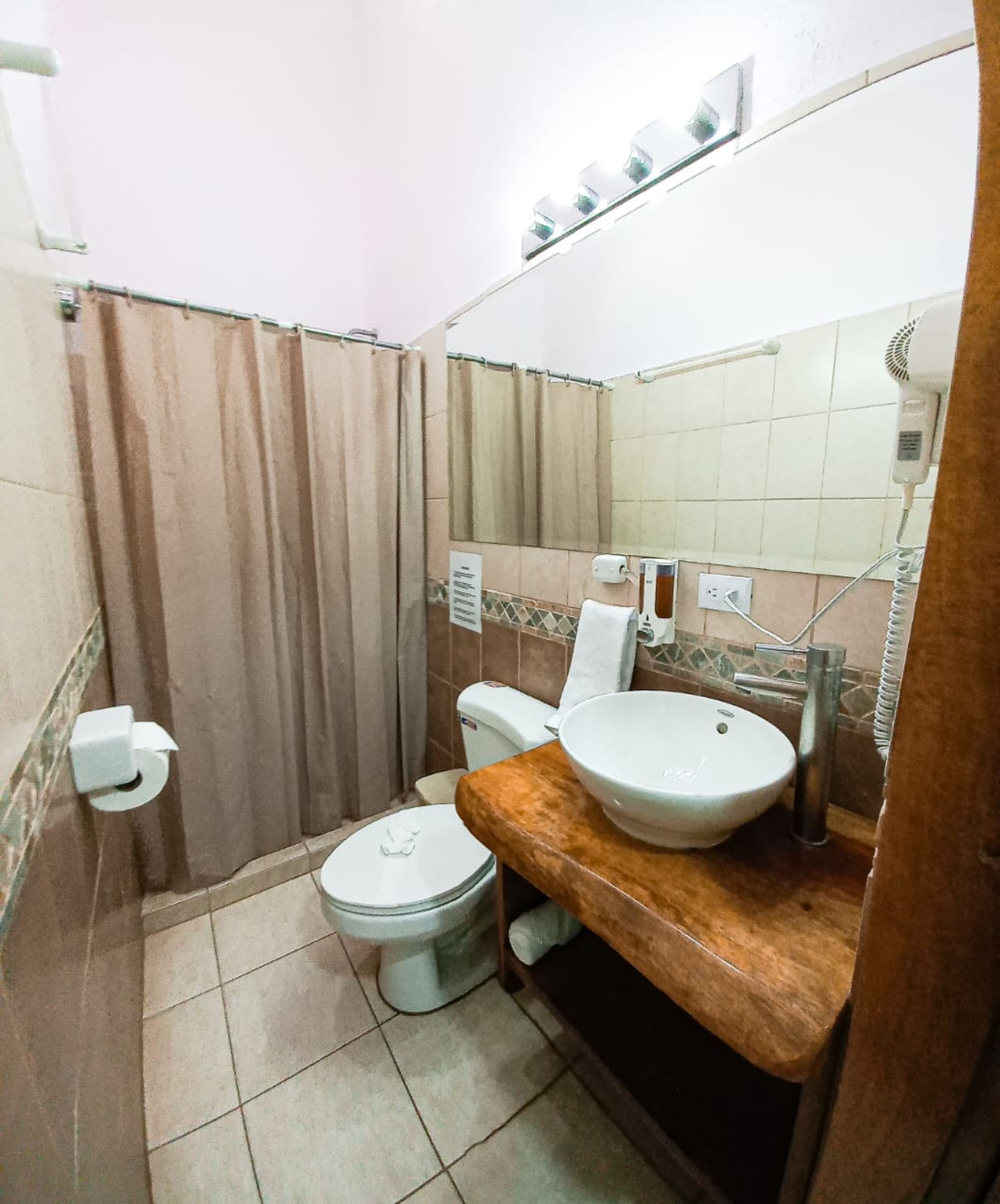 Un baño pequeño con inodoro, lavabo y ducha.