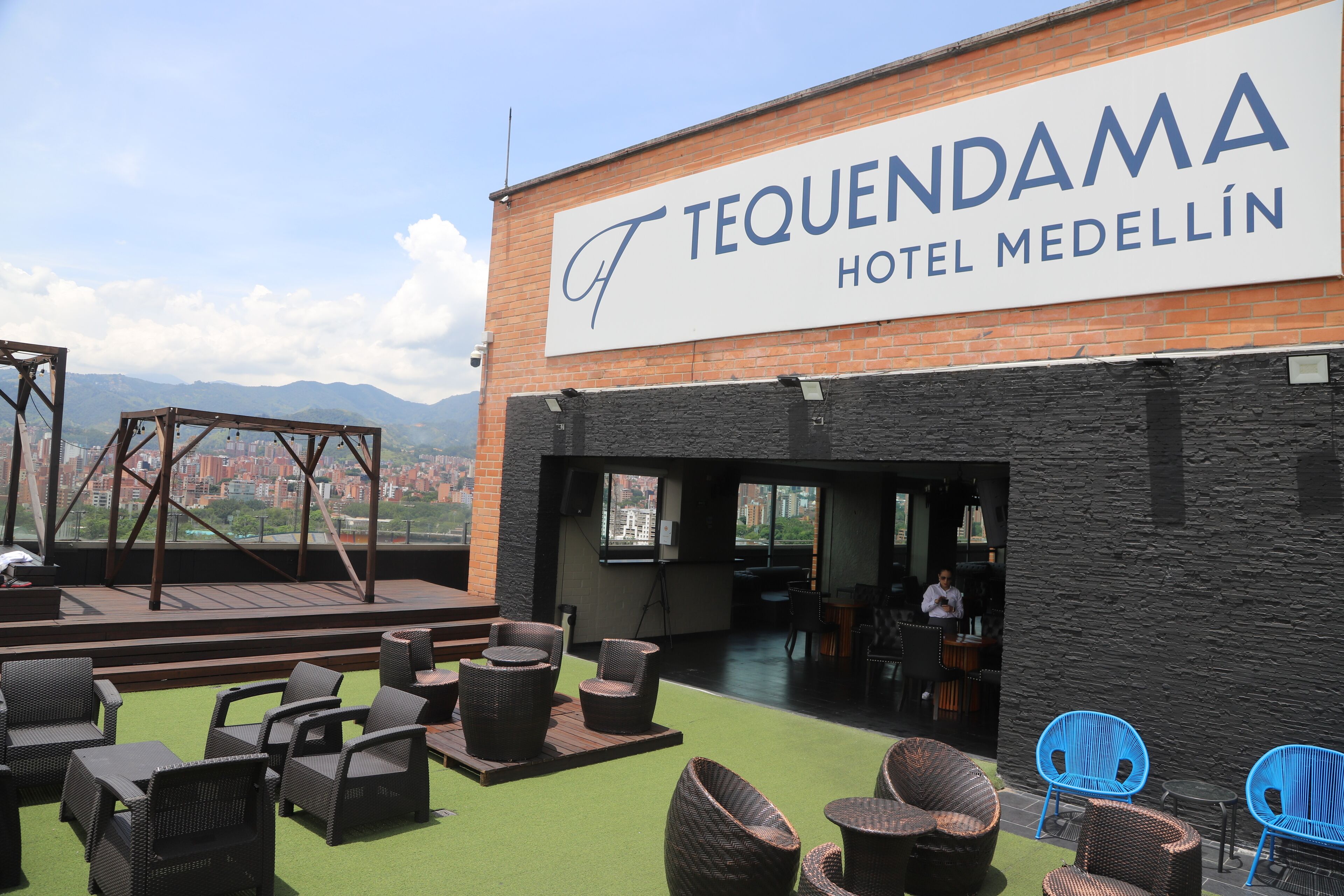 Hotel Tequendama Medellín con asientos al aire libre y vistas de la ciudad.