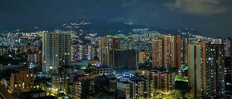 A nighttime cityscape with high-rise buildings and illuminated streets.