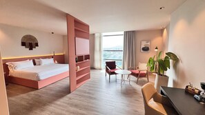 Suite estudio Deluxe, 1 cama King size | Edredón, minibar, caja de seguridad en la habitación y escritorio 