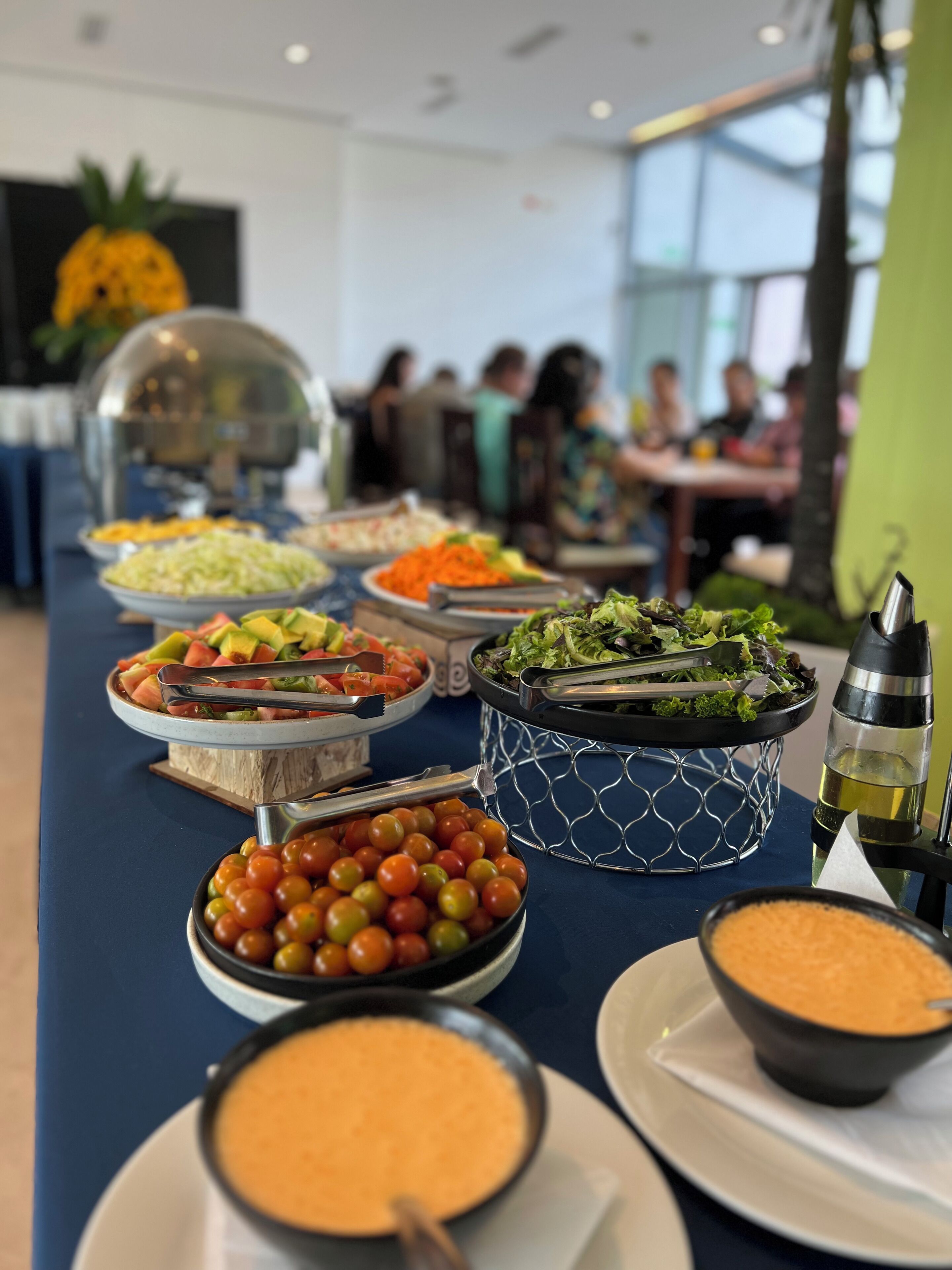A buffet table with various food items including salads, fruits, and dips.