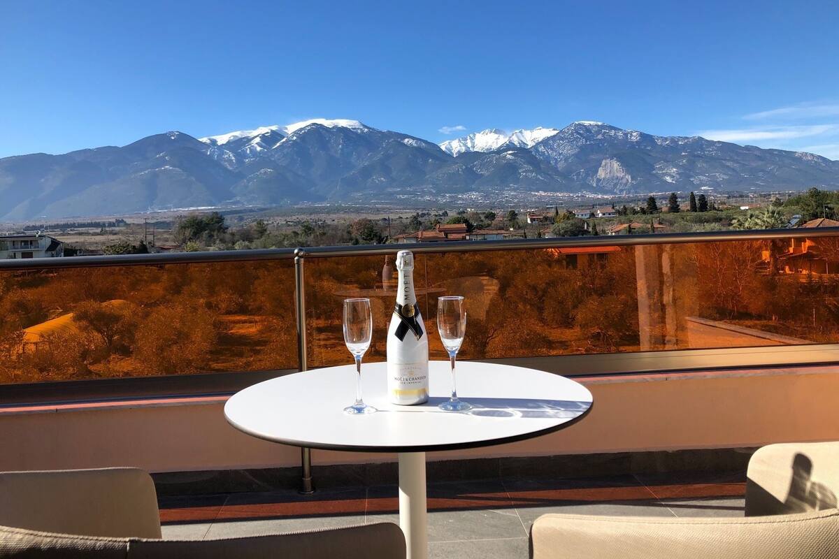 Ein Tisch mit einer Flasche Moët & Chandon Champagner und zwei Gläsern auf einem Balkon mit Blick auf eine Berglandschaft.