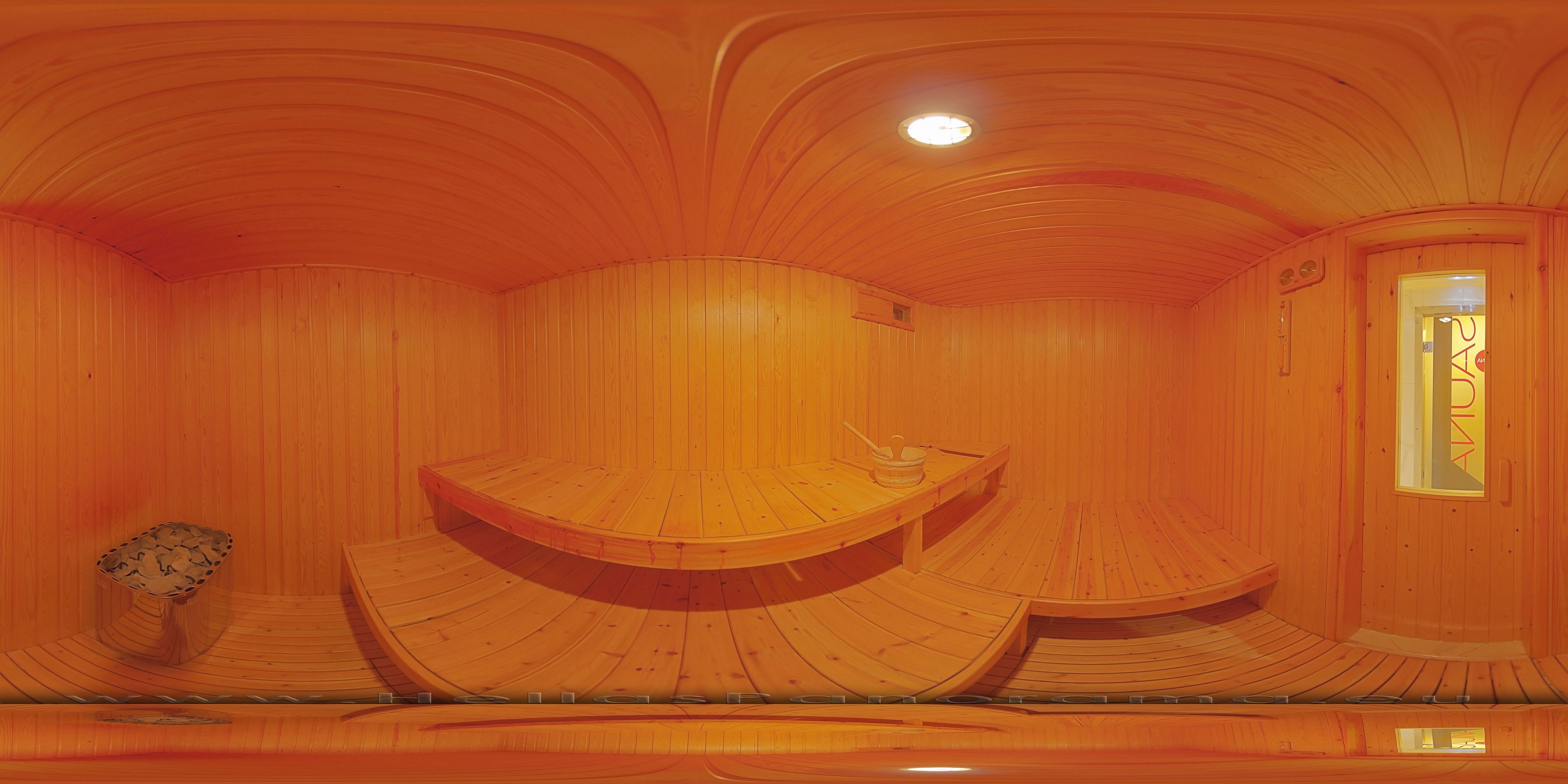 A wooden interior with curved wooden benches and a small table.