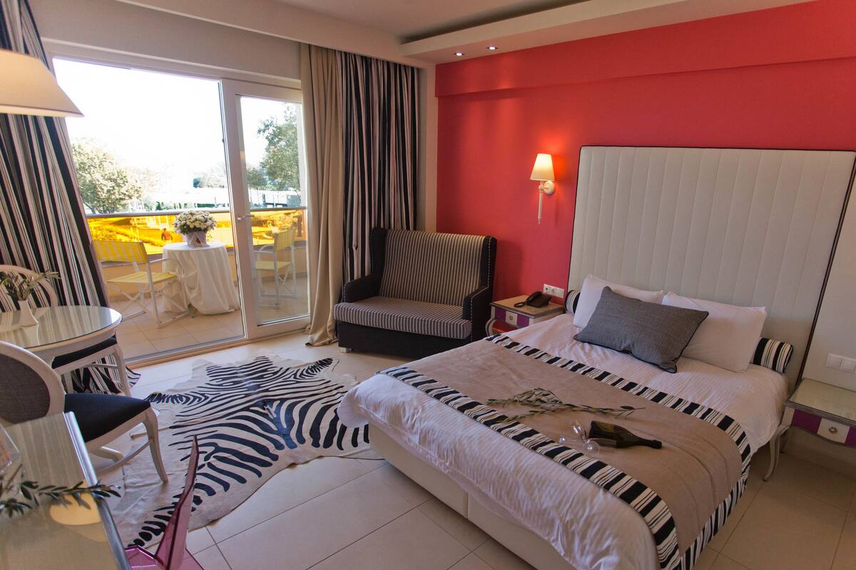 Ein Hotelzimmer mit einem Bett, einem Sessel, einem Tisch und einem Zebra-Teppich.