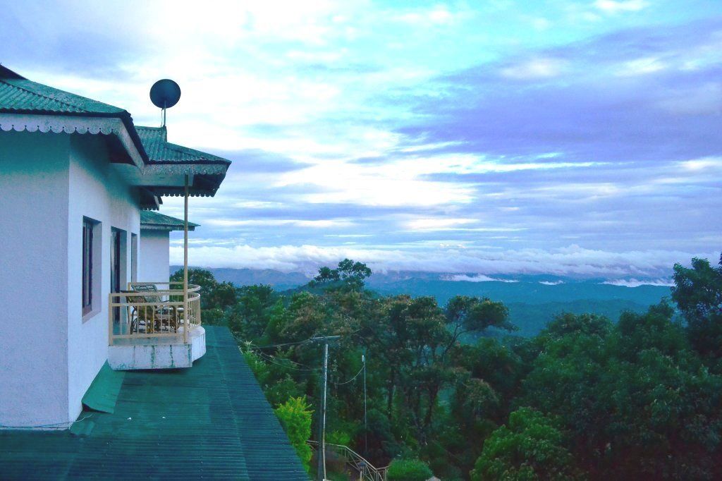 Un bâtiment doté d’un balcon donnant sur un paysage boisé.